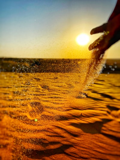 日落时水体附近的棕色沙子